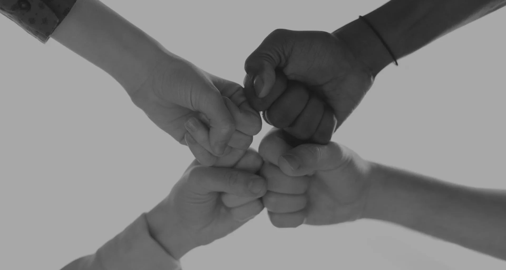 Cuatro puños unidos en señal de colaboración