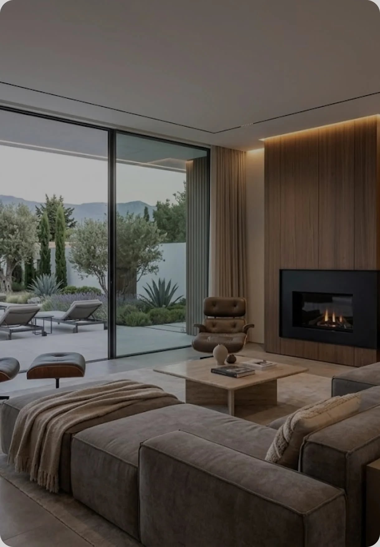 Salón con chimenea encendida y ventanal corrido al jardín