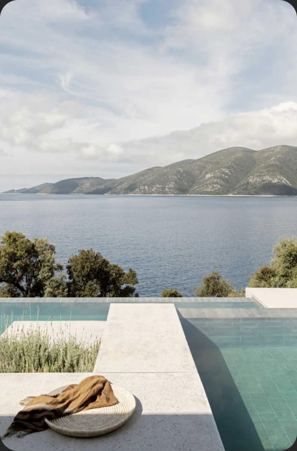 Piscina desbordante frente a la bahía y la montaña
