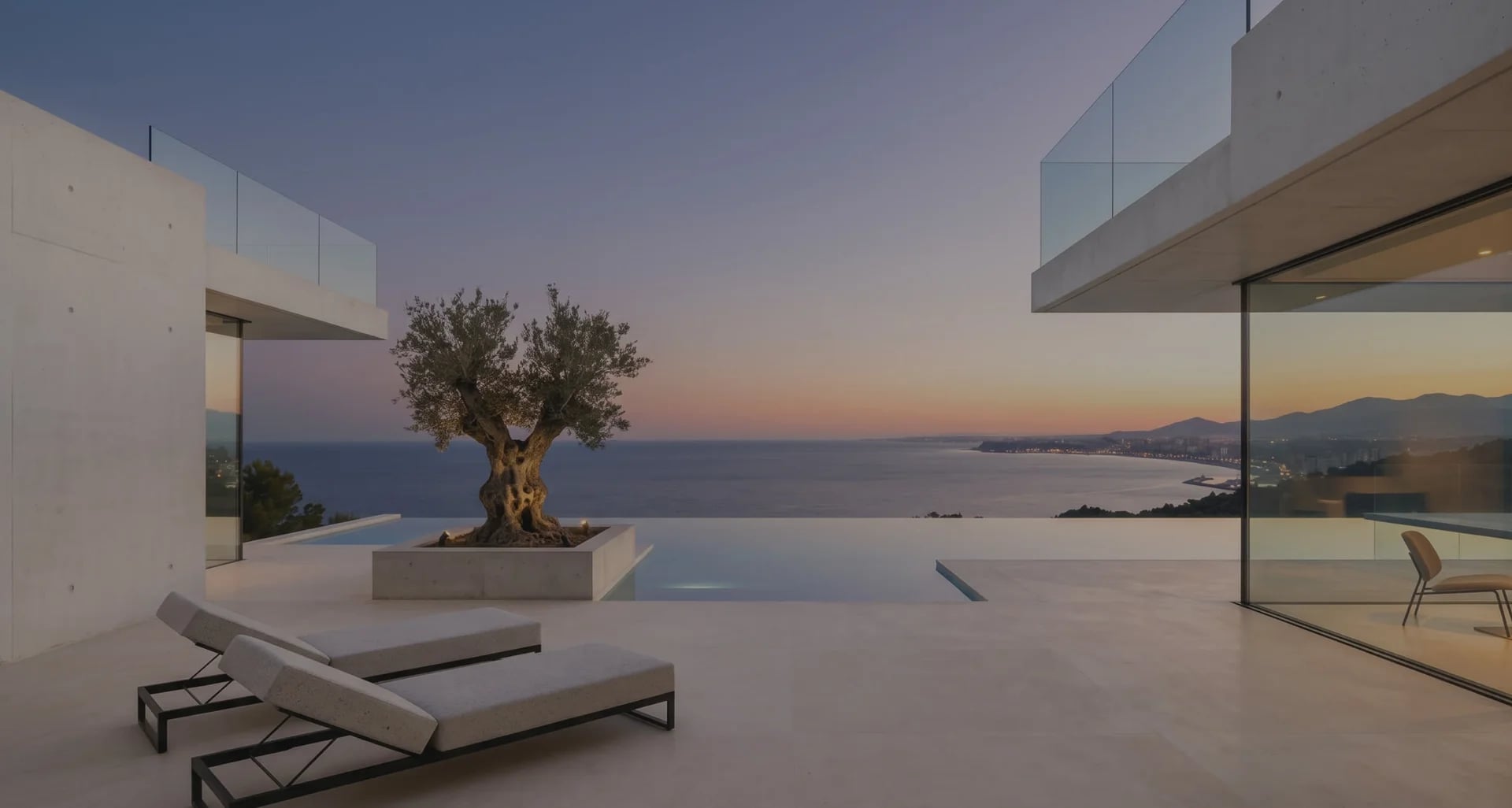 Terraza con tumbonas, olivo y vistas al mar al atardecer